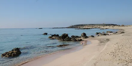 Różowawy piasek i skały na plaży Elafonisi na Krecie