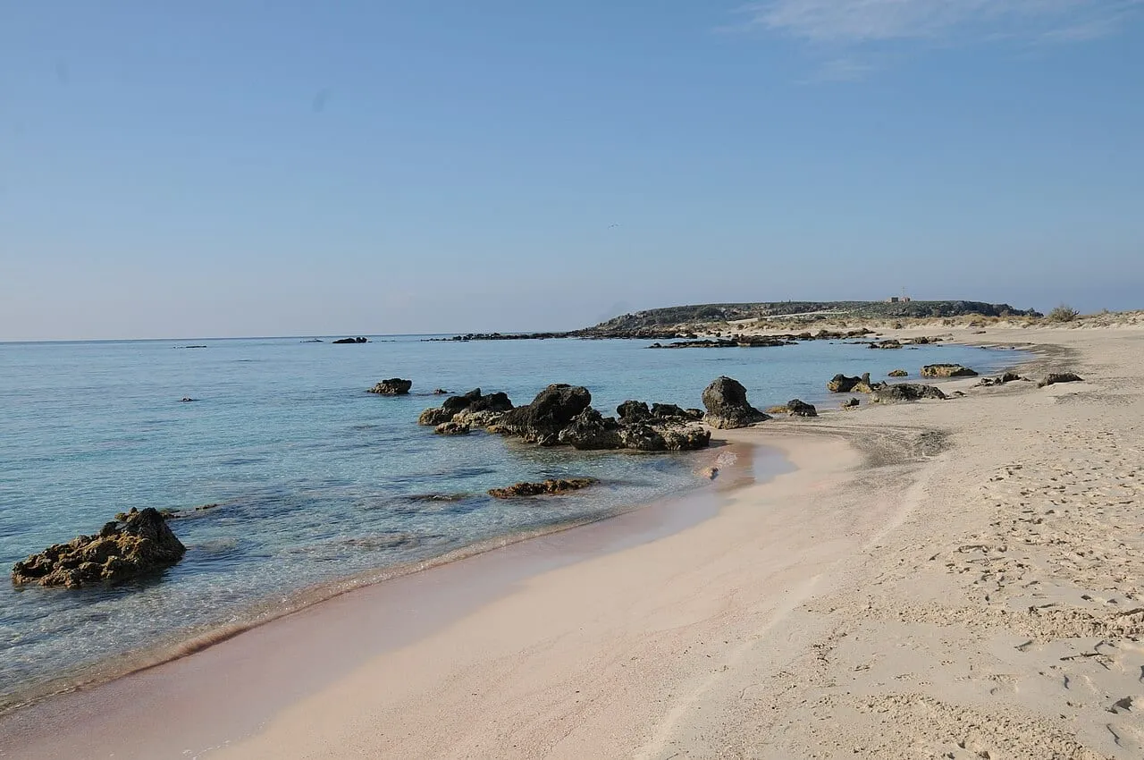 Różowawy piasek i skały na plaży Elafonisi na Krecie