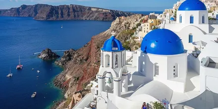 Trzy niebieskie kopuły kościołów w Oia na Santorini nad Morzem Egejskim