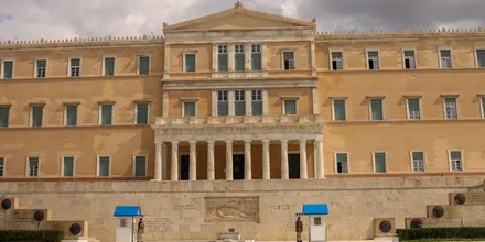 Gmach Parlamentu Greckiego przy placu Syntagma w Atenach z flagą Grecji na dachu
