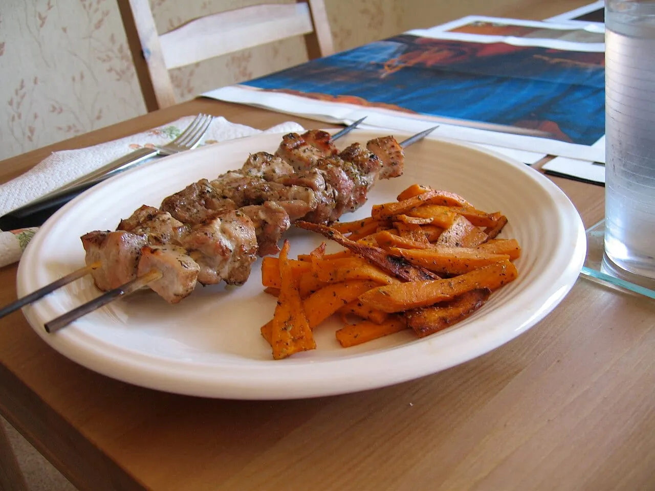 Greckie szaszłyki souvlaki z frytkami na talerzu